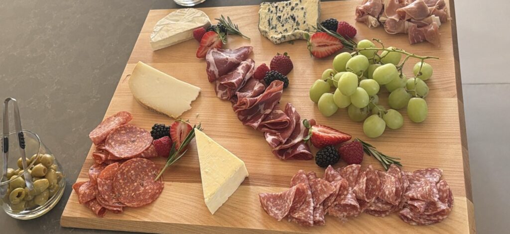 Charcuterie and cheese board with brie, blue cheese, aged cheddar, capicola, salami, prosciutto, grapes and fresh berries, served at a Culinary and Cork private chef dinner in Barrie, Ontario