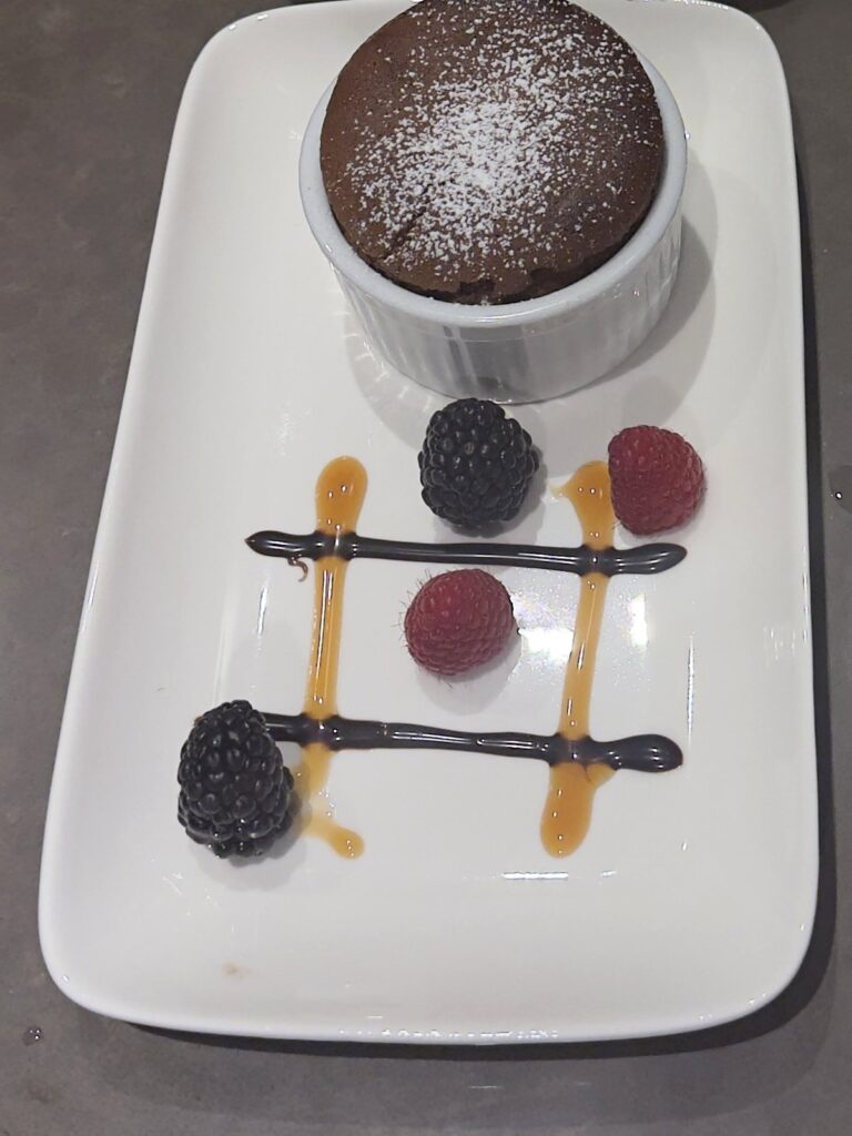Chocolate souffle with fresh berries and caramel, plated dessert course by Culinary & Cork private chef