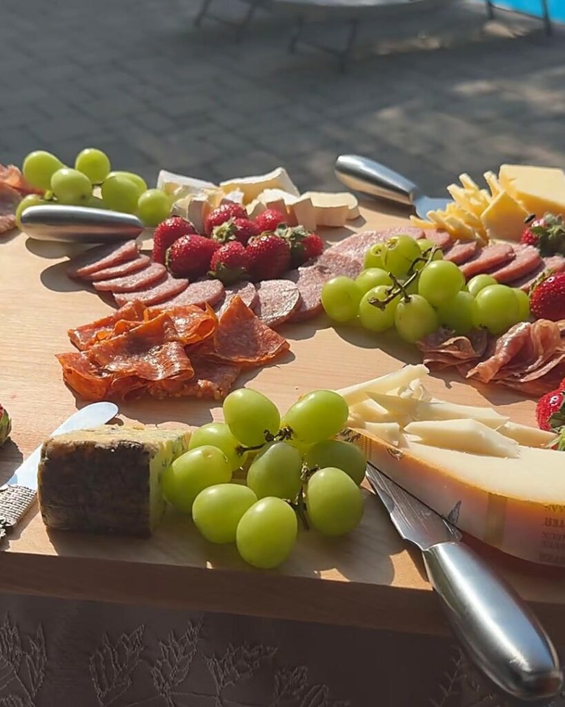 Poolside charcuterie and cheese board with prosciutto, salami, aged Beemster, grapes and strawberries at a Simcoe County private chef event