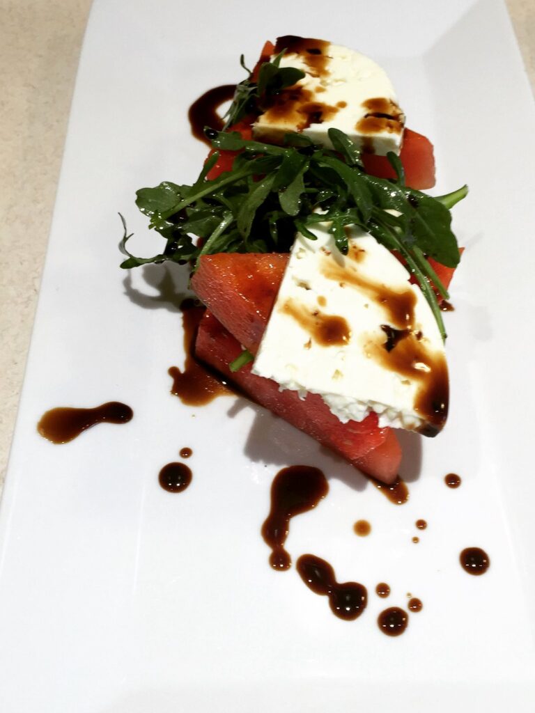 Watermelon and feta salad with arugula and balsamic, plated by a private chef in Barrie, Ontario